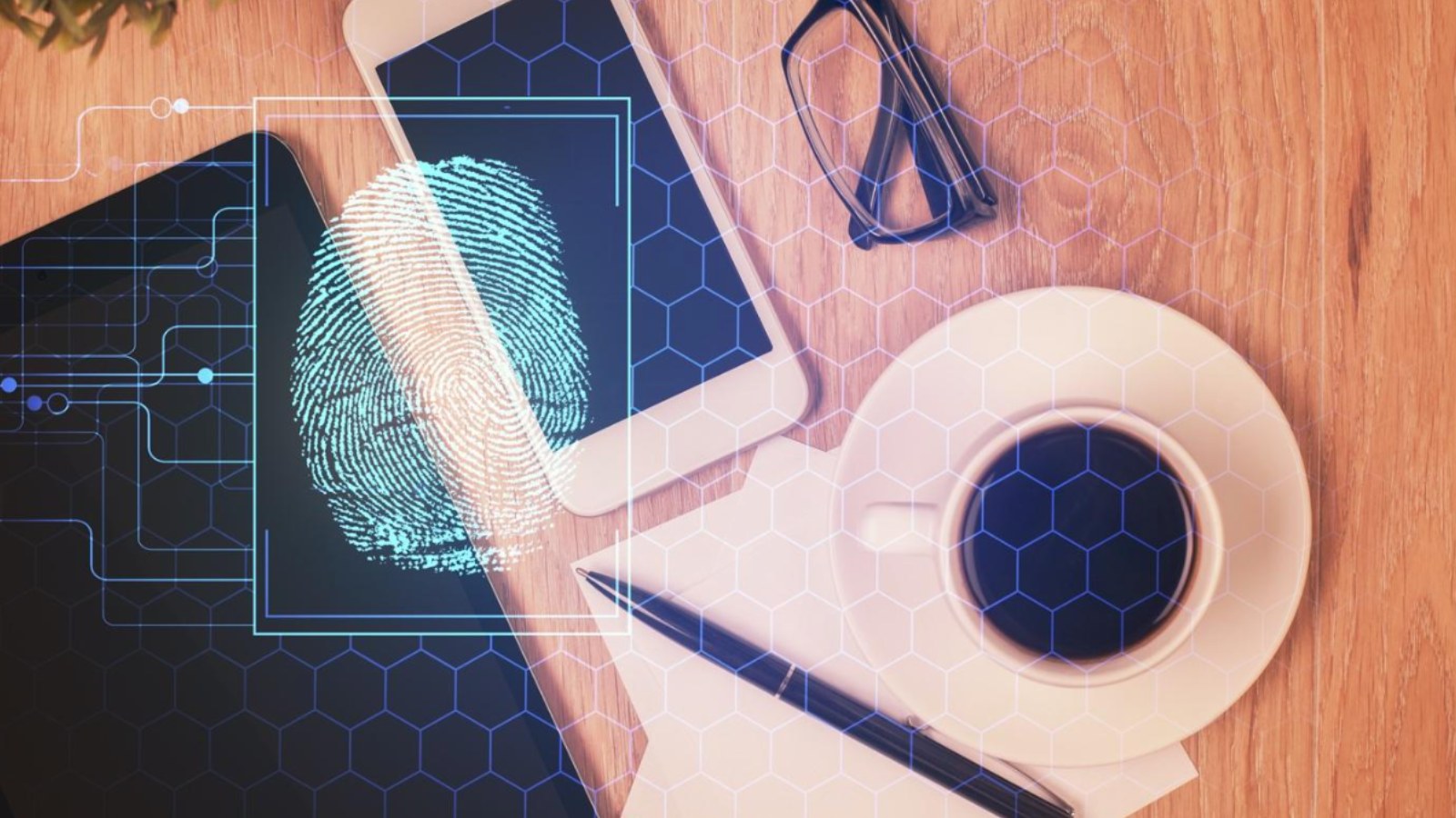 Concept image of a smartphone and digital tablet lying on a desk, with a hologram of a thumbprint superimposed. 